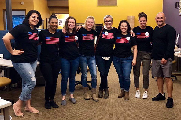 Seven women and one man standing together, looking at camera.