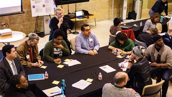 Group of people sitting at a table during a meeting.