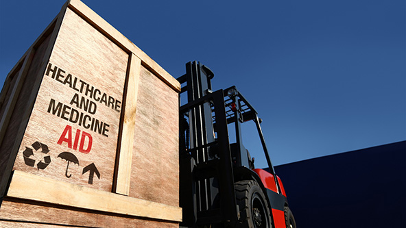 forklift truck with boxes on pallet marked health care and medicine aid