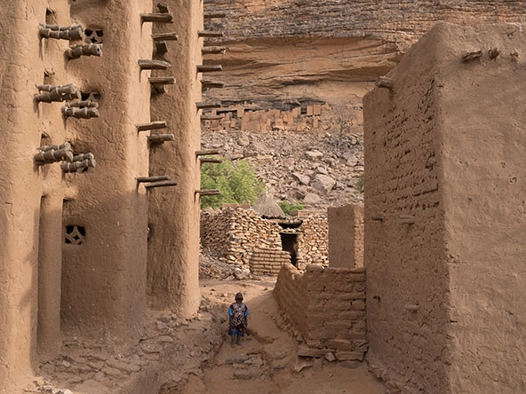 boy looking up between two tall sandstone structures