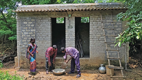 Family building a bathroom and toilet outside their home in India