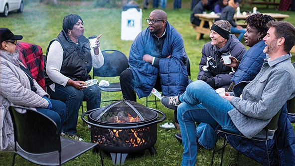 A group of people sitting around a fire.