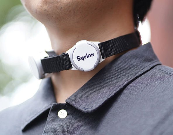 Person wearing a electrolarynx device around their neck