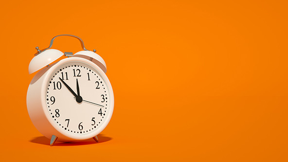 Alarm clock on orange background