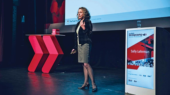 Woman making a presentation on a stage.