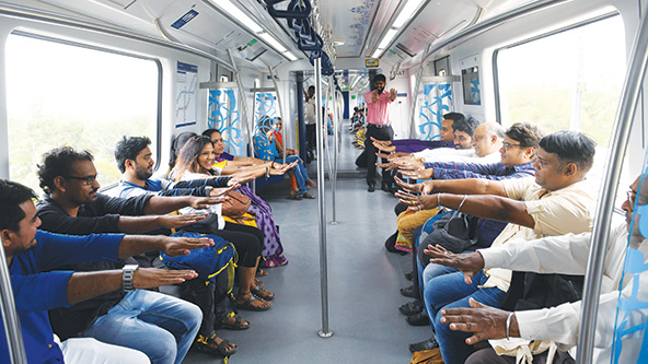 Train passengers with arms extended doing yoga in their train streets
