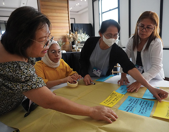 Women working together to put ideas on paper together 