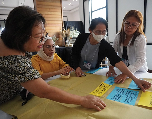 Women working together to put ideas on paper together 