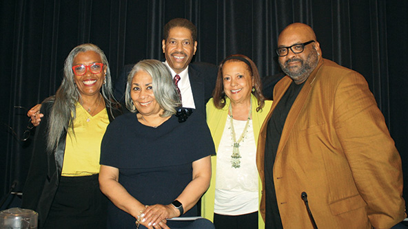 Black Radio personalities standing; smiling at camera