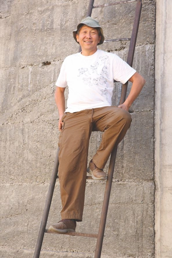 Tolondu Toichubaev stands on a ladder at the Tolon Muse