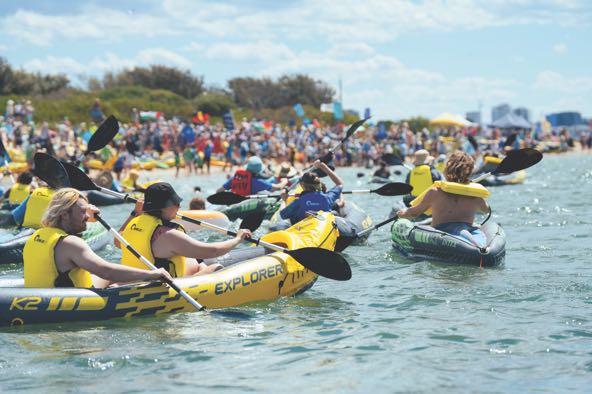 activists wearing yellow life jackets in kayaks in Newcastle Harbor in Australia