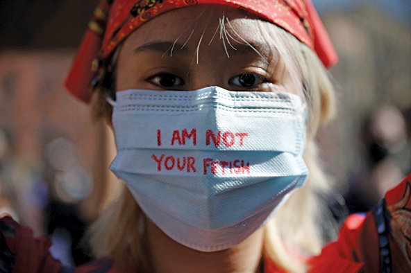 Asian woman wearing surgical mask that says 