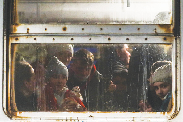 Ukrainian refugees looking out a train window