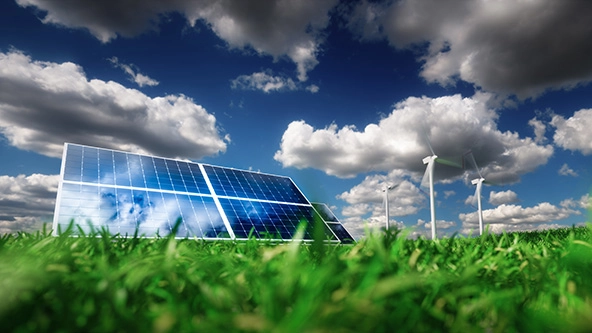 Solar panels and wind turbines on a grass field