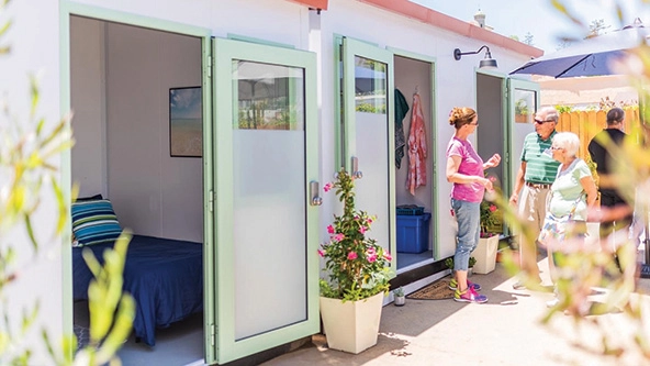 Small cabins with beds, flowers outside