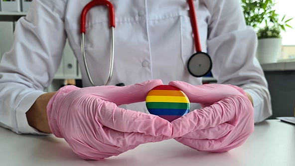doctor holding lgbt badge 
