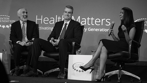 Three people seated on a stage in a panel discussion