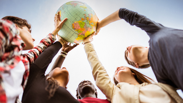 Teenagers lifting up a globe