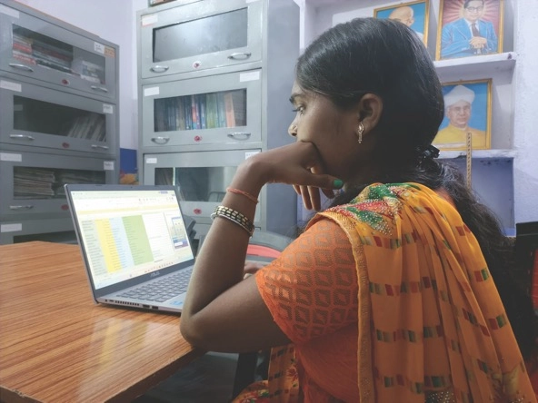woman looking at a laptop in a library in Kulharia village in Bihar's Bhojpur district in India 
