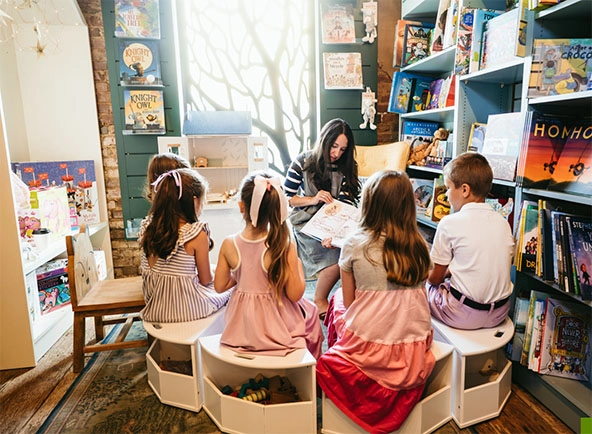 children sit around woman reading a storybook in a bookstore