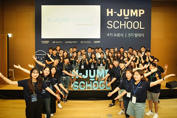 Students stand in front of sign that reads 