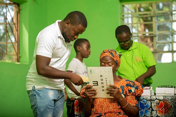 Woman holding an eyechart in a clinic.