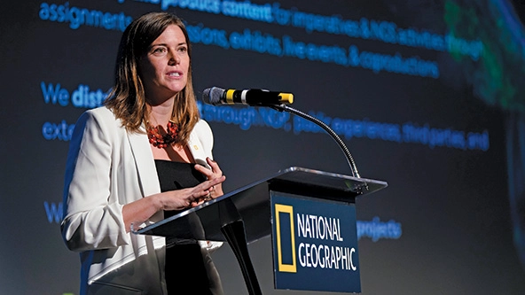 Woman speaking into a microphone at a podium