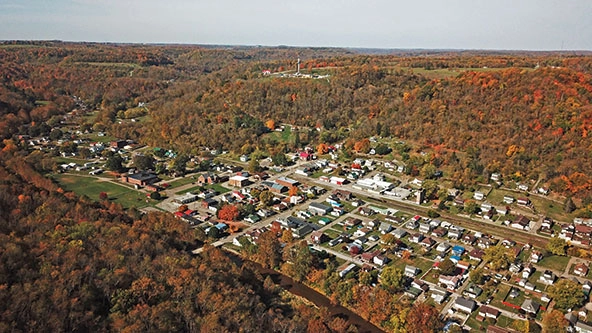 An aerial view of Dillonvale, Ohio, showing houses, buildings, streets, and wooded areas