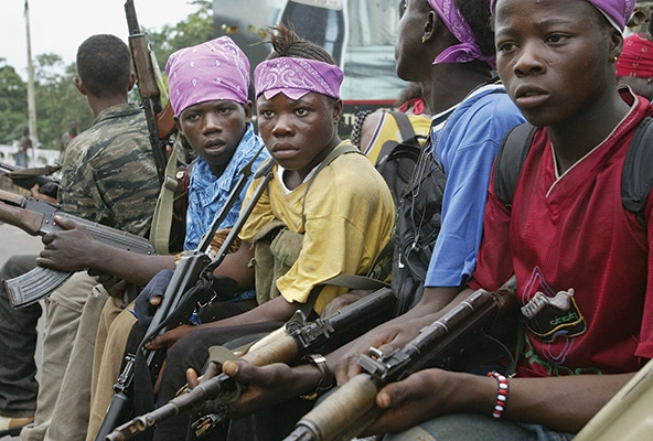 Liberian child soldiers sitting and holding guns