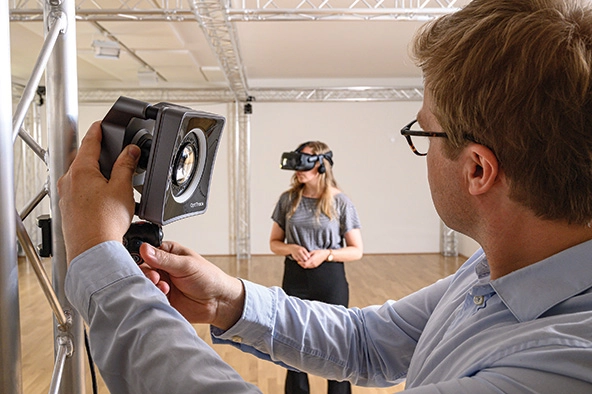 Woman in virtual reality headset testing the equipment as an operator looks on
