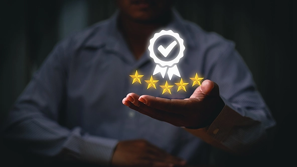 Hand holding hovering image of golden five stars and ribbon with checkmark