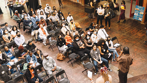 Overhead shot of people seated in rows listening to a presentation
