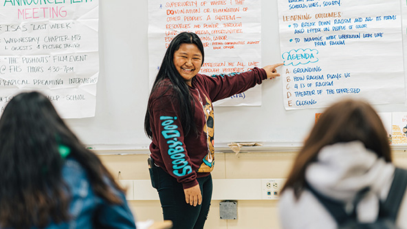 Student pointing at schoolwork on a whiteboard