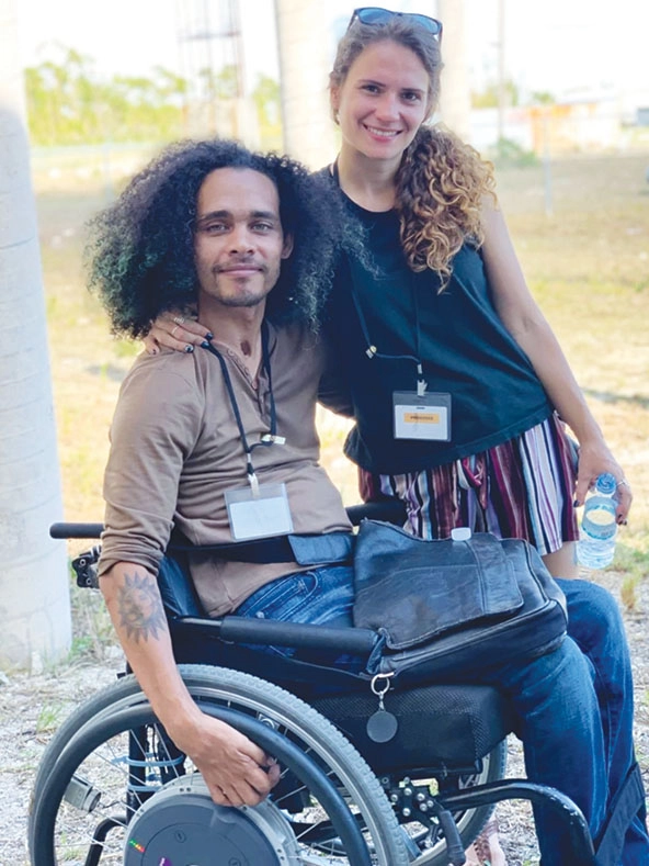 man in a wheelchair and woman with arm around him
