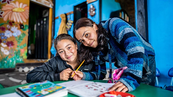 Student and teacher in a classroom looking at camera