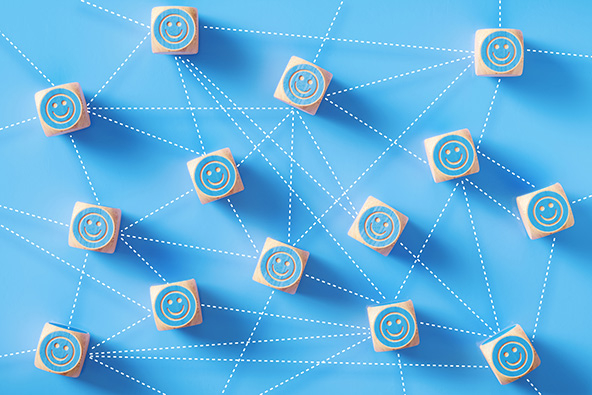 Smiley face symbols drawn on blue wood blocks which are connected by dotted lines